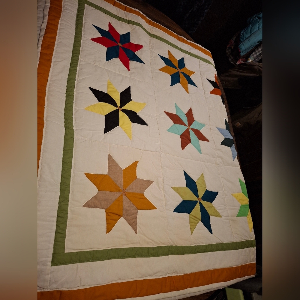 This colorful handmade quilt features a unique 8-point star pattern